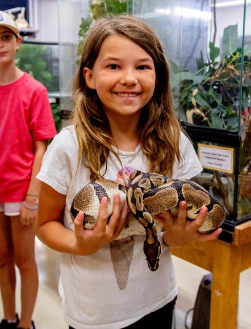 Child holding a snake from on campus museum 